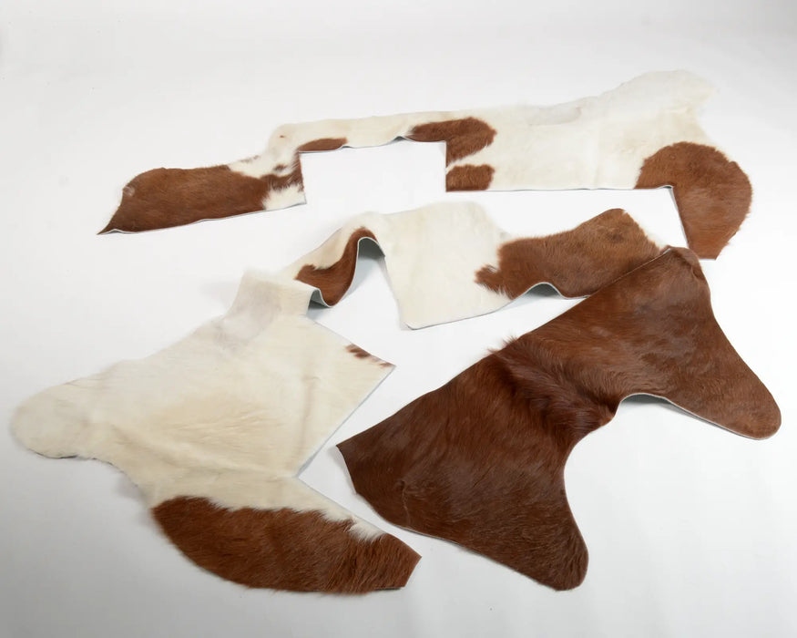 Four cowhide rug scraps with brown and white patches