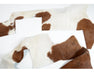 Brown and white cowhide hide pieces for crafting or upholstery.