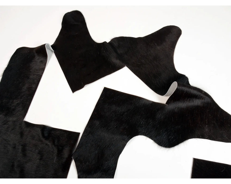 Black cowhide rug pieces with natural hair-on-hide texture for craft.
