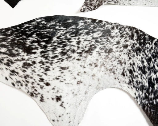 Cowhide rug scraps with a black and white speckled pattern, use for crafts.