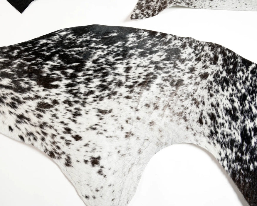 Cowhide rug scraps with a black and white speckled pattern, use for crafts.