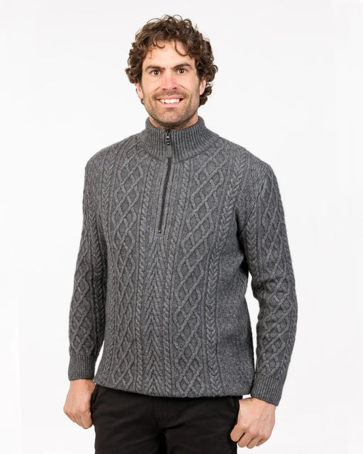 Man wearing a gray cable knit sweater made from possum merino wool