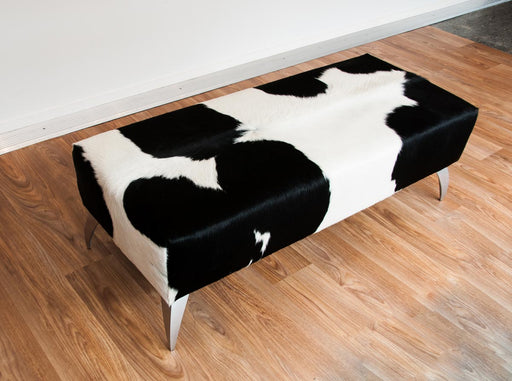 Black and white cowhide ottoman with metal legs