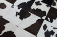 Dark brown and white cowhide patchwork rug close up