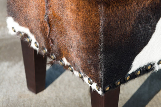 Cowhide ottoman with stud detail